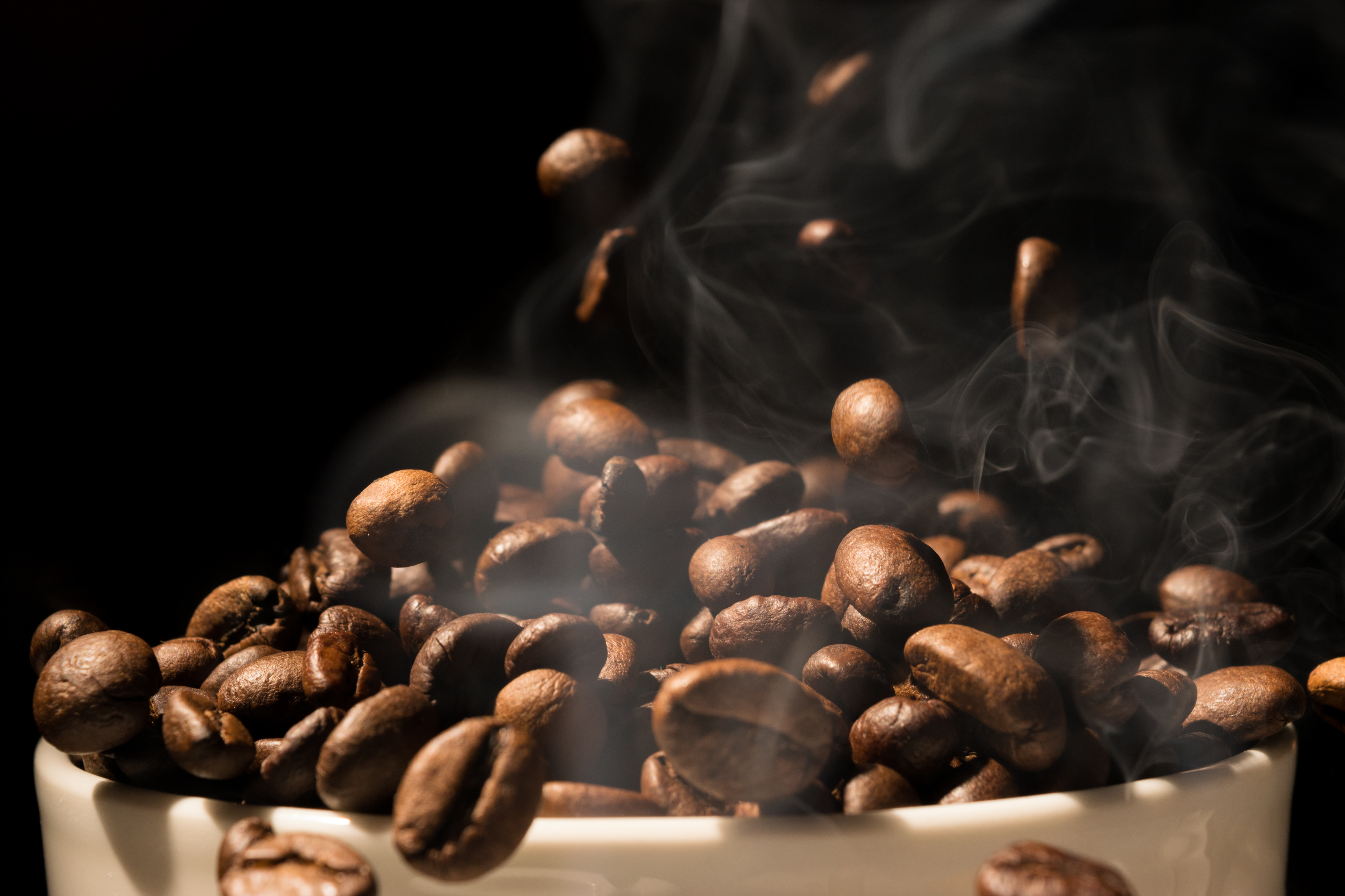 Coffee mug full of coffee beans with smoke