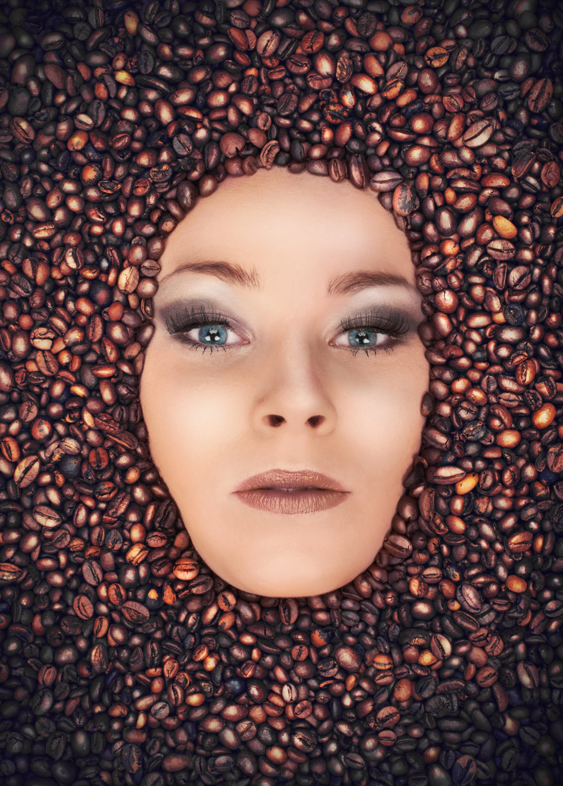 Concept of coffee with attractive girl immersed in coffee beans